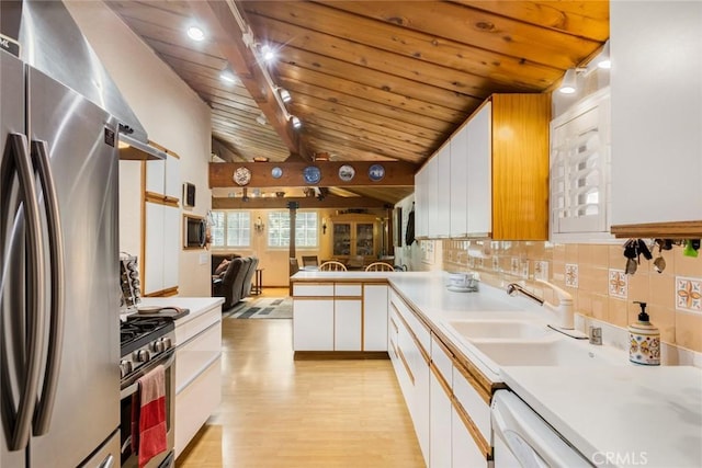 kitchen featuring a sink, light wood-type flooring, vaulted ceiling with beams, wood ceiling, and appliances with stainless steel finishes