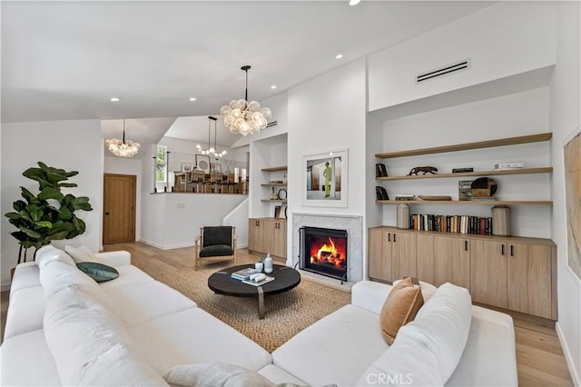 living room featuring recessed lighting, a chandelier, light wood finished floors, baseboards, and visible vents