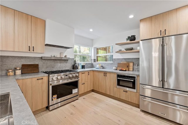 kitchen featuring open shelves, light brown cabinets, high quality appliances, and light countertops