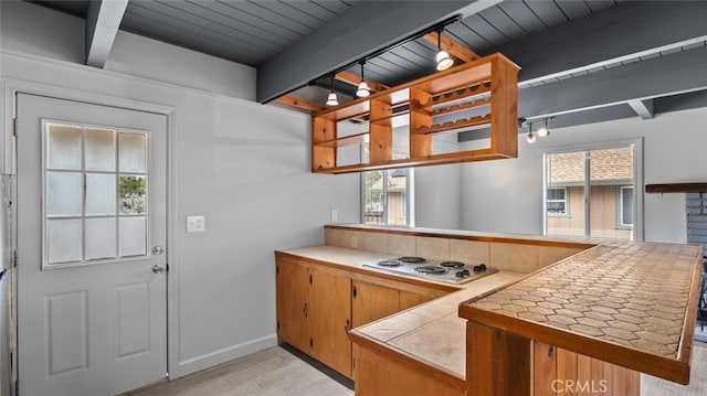 kitchen with electric cooktop, tile countertops, beamed ceiling, light wood-type flooring, and a peninsula