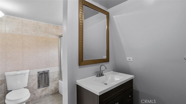 bathroom with toilet, vanity, visible vents, and combined bath / shower with glass door