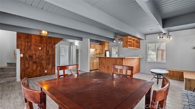 dining room featuring stairway, wood finished floors, and beamed ceiling