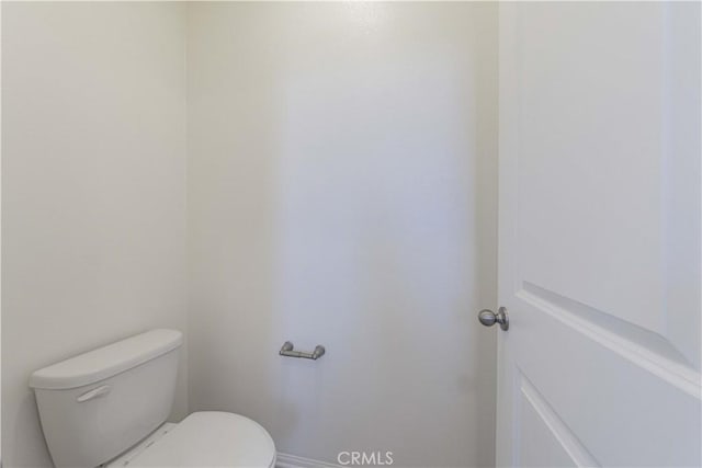 bathroom with baseboards and toilet