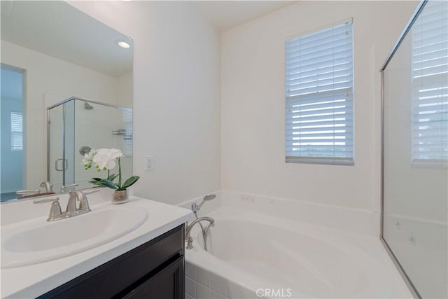 full bath with vanity, a shower stall, a bath, and a wealth of natural light