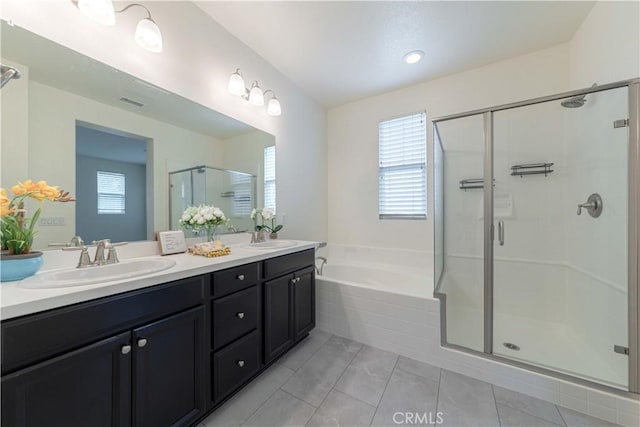 full bathroom featuring a sink, a wealth of natural light, a garden tub, and a stall shower