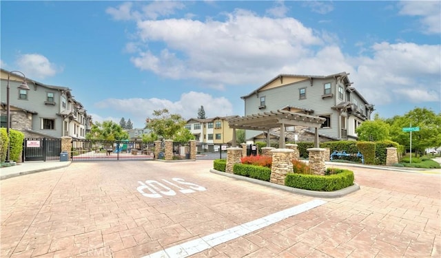 view of road with a residential view, a gate, a gated entry, and curbs