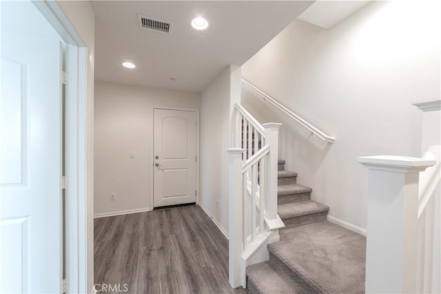 stairs featuring visible vents, recessed lighting, baseboards, and wood finished floors
