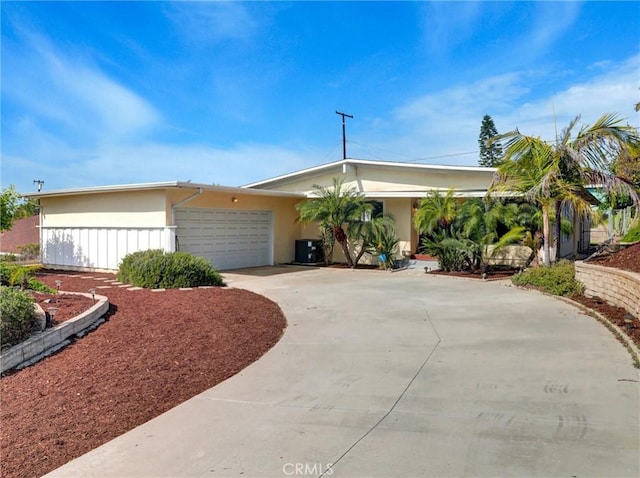 single story home with stucco siding, driveway, cooling unit, and a garage