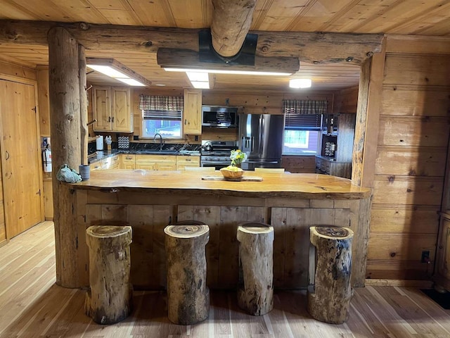 kitchen featuring wood ceiling, appliances with stainless steel finishes, a sink, and light wood-type flooring