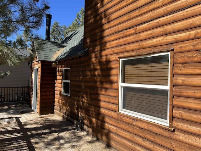 view of side of home with roof with shingles