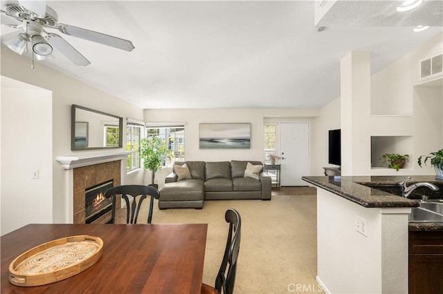 dining space featuring visible vents, light carpet, a healthy amount of sunlight, and a fireplace