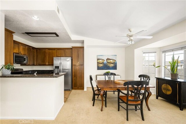 kitchen with ceiling fan, light colored carpet, stainless steel appliances, baseboards, and a peninsula