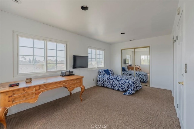 bedroom with baseboards, carpet floors, and a closet