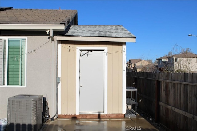 view of shed with fence and central AC unit