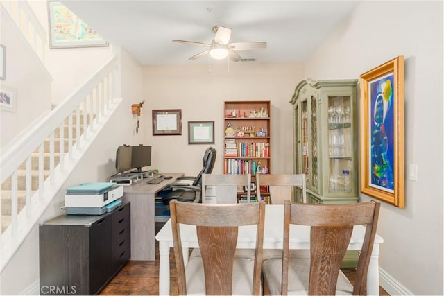 office featuring dark wood-style flooring, visible vents, baseboards, and ceiling fan