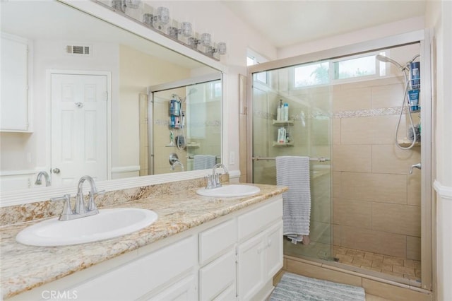 full bathroom with a shower stall, a sink, and visible vents