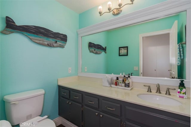 bathroom featuring toilet, vanity, and an inviting chandelier