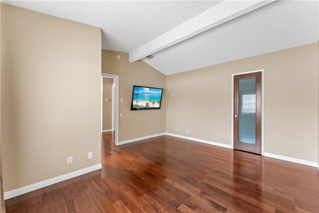 spare room with wood finished floors, vaulted ceiling with beams, and baseboards