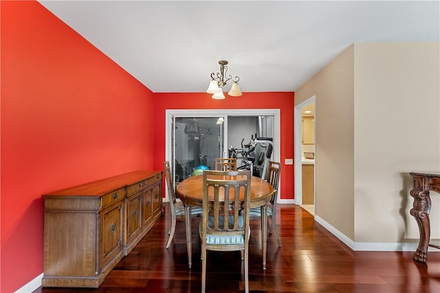 dining area featuring a notable chandelier, dark wood-style flooring, and baseboards