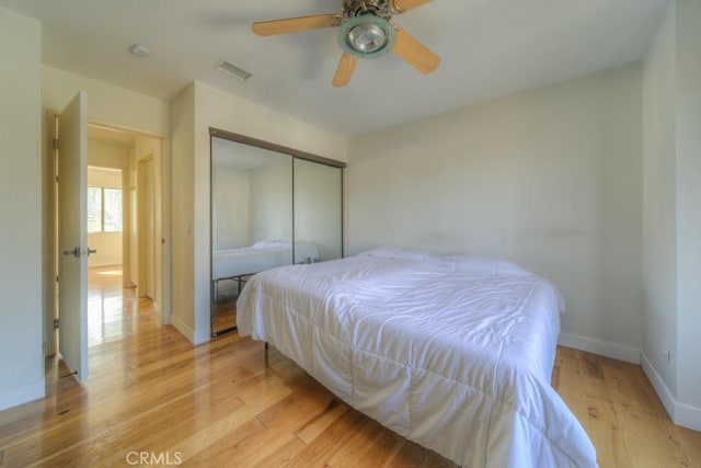 10917 Breezy Meadow Dr, Moreno Valley, CA 92557 - bedroom with light wood finished floors, visible vents, a ceiling fan, a closet, and baseboards
