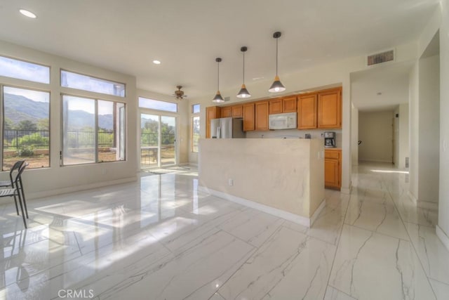 10917 Breezy Meadow Dr, Moreno Valley, CA 92557 - kitchen featuring recessed lighting, stainless steel fridge with ice dispenser, visible vents, white microwave, and hanging light fixtures