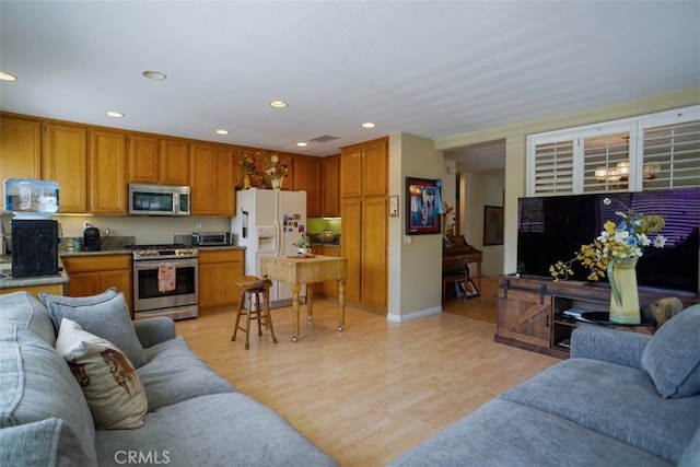 living room with light wood-style flooring, visible vents, baseboards, a toaster, and recessed lighting