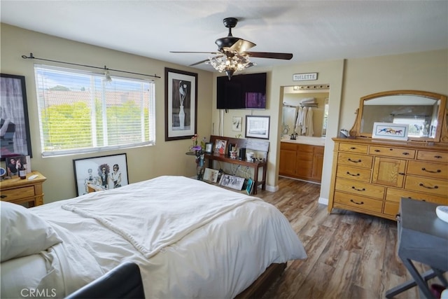 bedroom with ceiling fan, wood finished floors, and connected bathroom