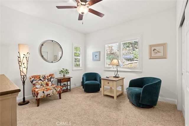 sitting room with carpet floors, baseboards, ceiling fan, and a wealth of natural light