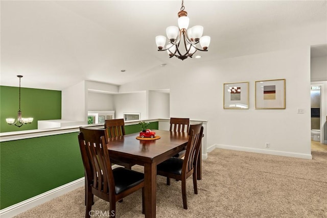 dining area featuring an inviting chandelier, baseboards, vaulted ceiling, and light carpet