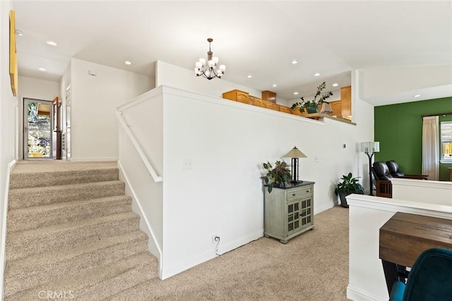 stairway with carpet floors, recessed lighting, and a notable chandelier