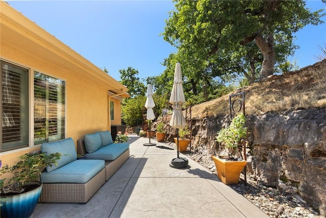 view of patio with an outdoor living space and fence