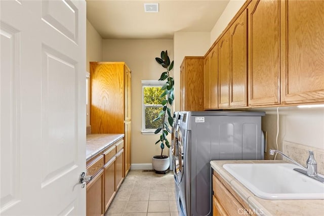 washroom featuring visible vents, cabinet space, a sink, baseboards, and light tile patterned floors