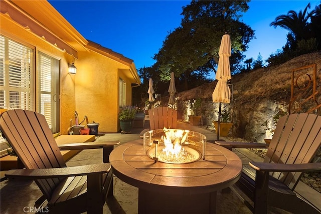 patio at twilight featuring an outdoor fire pit
