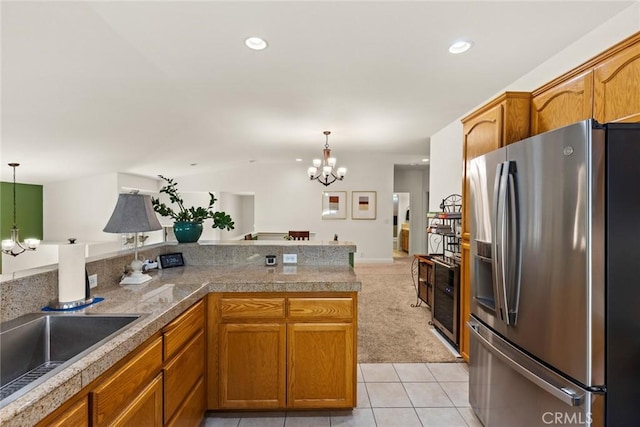 kitchen featuring tile countertops, a notable chandelier, hanging light fixtures, and stainless steel fridge with ice dispenser