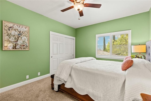 bedroom with baseboards, a ceiling fan, carpet, and a closet