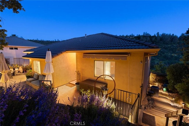 back of property featuring a patio, stucco siding, and a tile roof