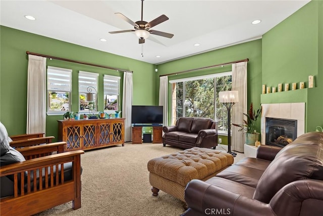 carpeted living room with ceiling fan, recessed lighting, and a tile fireplace