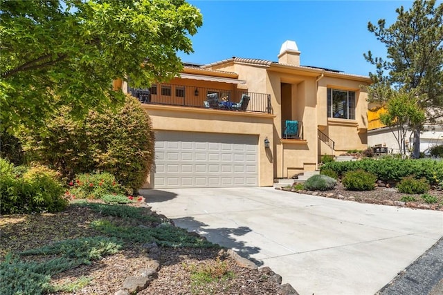 view of front of home featuring a chimney, driveway, stucco siding, and a balcony
