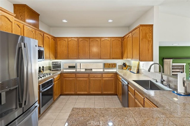 kitchen featuring a sink, light tile patterned floors, stainless steel appliances, and brown cabinets