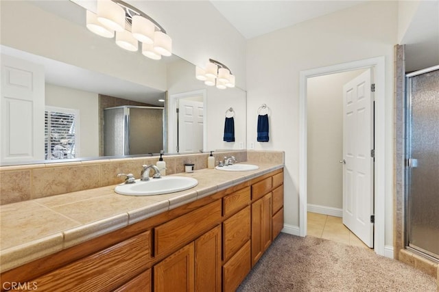 full bath featuring a sink, a shower stall, and double vanity