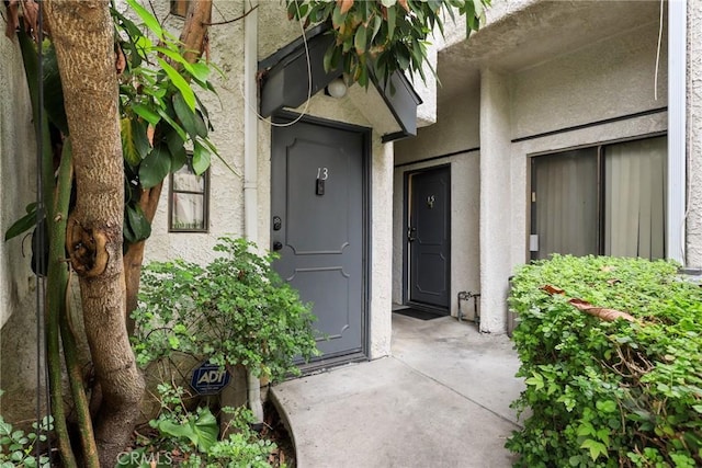 entrance to property featuring stucco siding