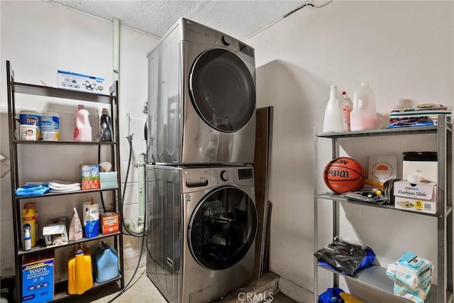 clothes washing area with stacked washer / dryer, a textured ceiling, and laundry area