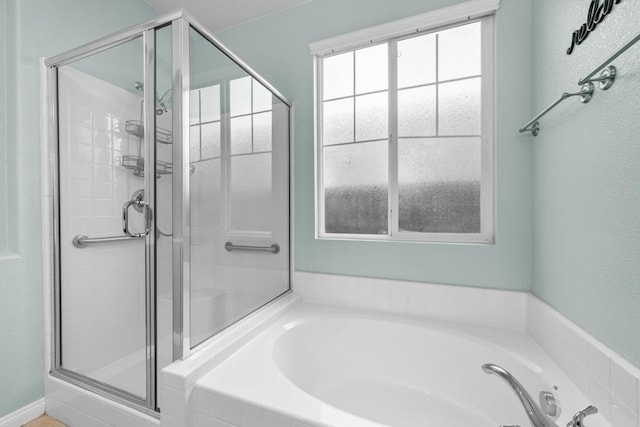 bathroom featuring a bath and a shower stall