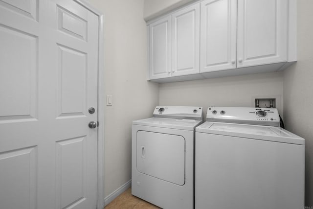 laundry area with washer and dryer, baseboards, and cabinet space