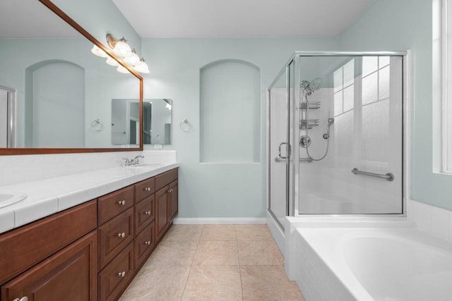 bathroom featuring a shower stall, tile patterned flooring, double vanity, a sink, and a tub