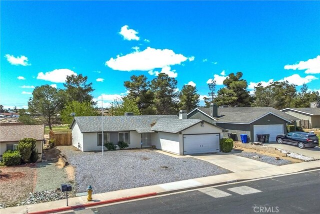 ranch-style house with a garage, stucco siding, fence, and concrete driveway