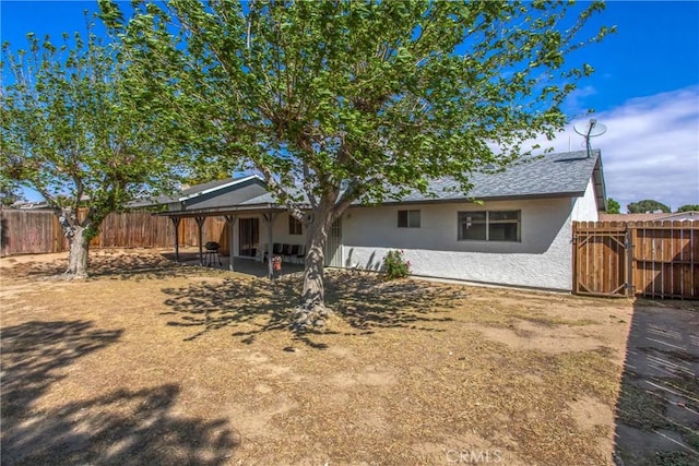 rear view of house featuring a patio, a fenced backyard, and stucco siding