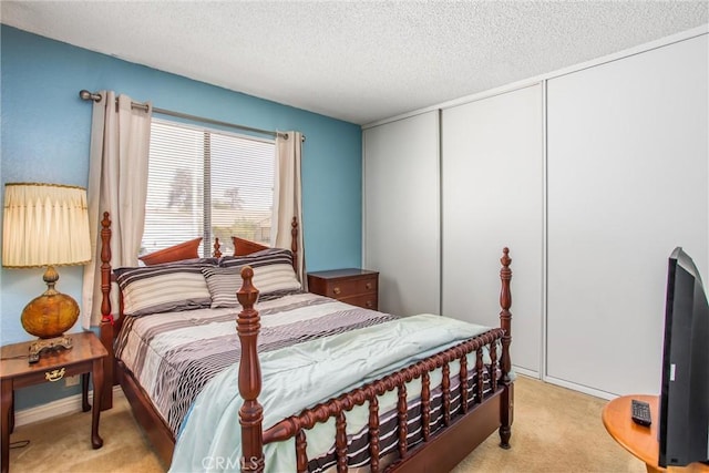 bedroom with light carpet, a closet, and a textured ceiling