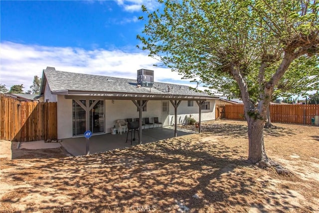 rear view of house featuring central air condition unit, a fenced backyard, a patio area, and stucco siding