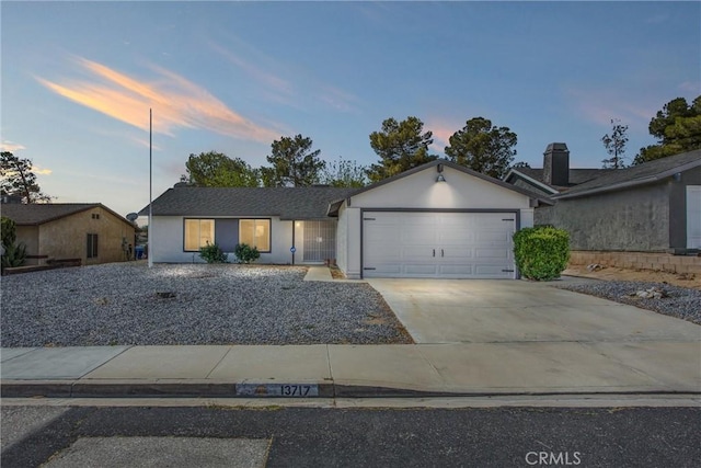 ranch-style home with a garage, stucco siding, and concrete driveway